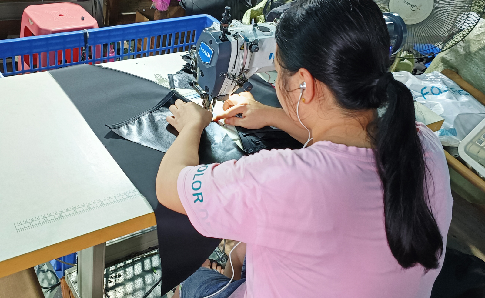ZRC factory worker operating industrial sewing machine on pet playpen mesh panel